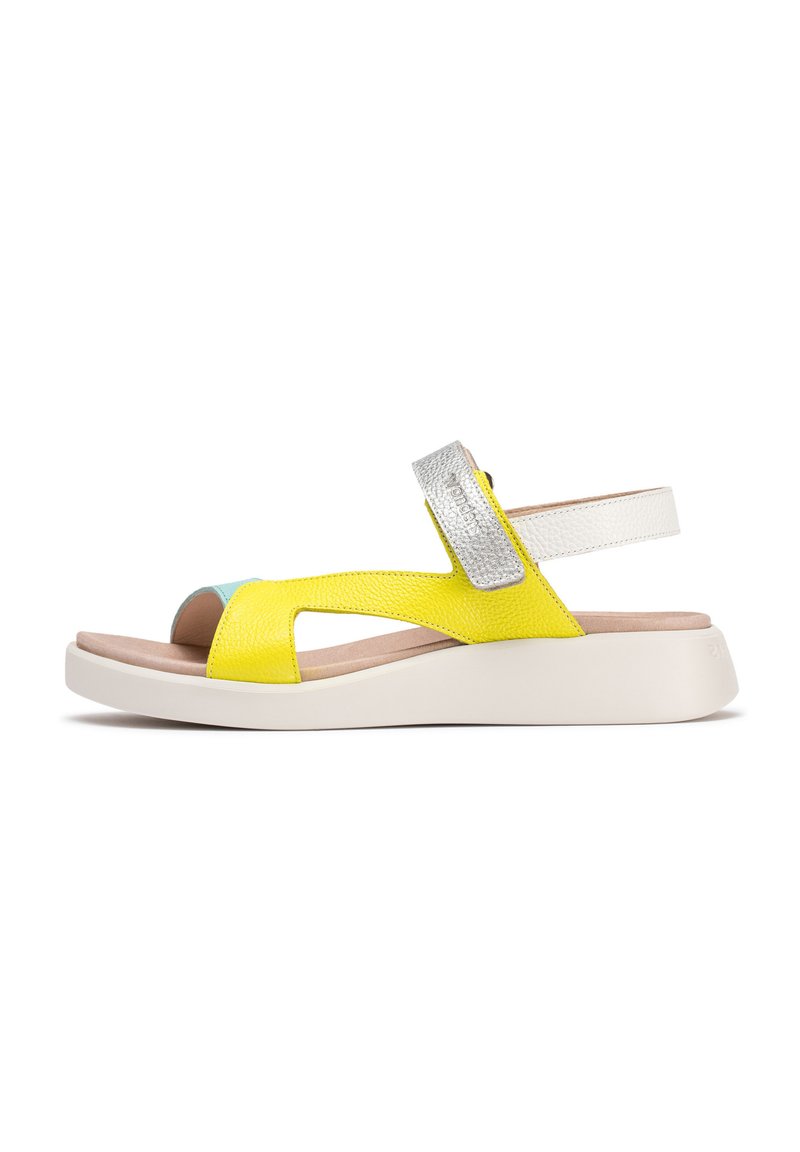 Sándalo de cuero amarillo con acentos plateados, diseño de punta abierta, correa ajustable, tacón blanco y parte superior texturizada. Suela liviana y acolchada.