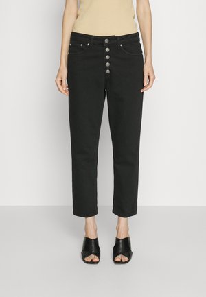 Zwarte high-waisted jeans met een rechte pijp, voorzien van een vijfknops sluiting en voorzakken. Gestyled met zwarte open-toe haksandalen.