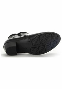 Schwarze Leder-Stiefelette mit einem klobigen Absatz, strukturiertem Gummisohle mit Profil und einem Reißverschluss im Inneren für einfaches Anziehen.