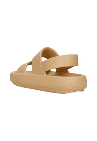 Beige schoeisel met een brede band en een gestructureerd oppervlak. Heeft een open teen en achterkant met een gevoerde, dikke zool voor comfort.