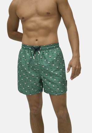 Bañador verde con un patrón de veleros, cinturilla elástica y cordón. El material parece ligero y suave, con un ajuste relajado.