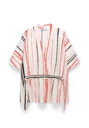 Giacca stile kimono bianca con strisce verticali a pennellate rosse e nere e cintura annodata in vita.