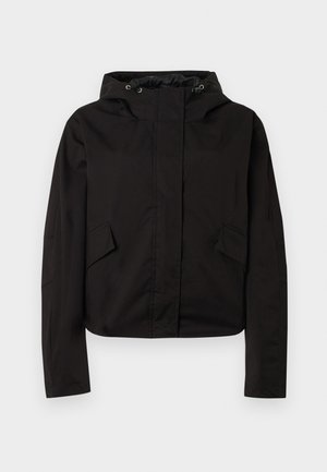 Veste courte noire en tissu lisse, avec capuche, fermeture éclair frontale et poches latérales inclinées. Design minimaliste avec manches longues.