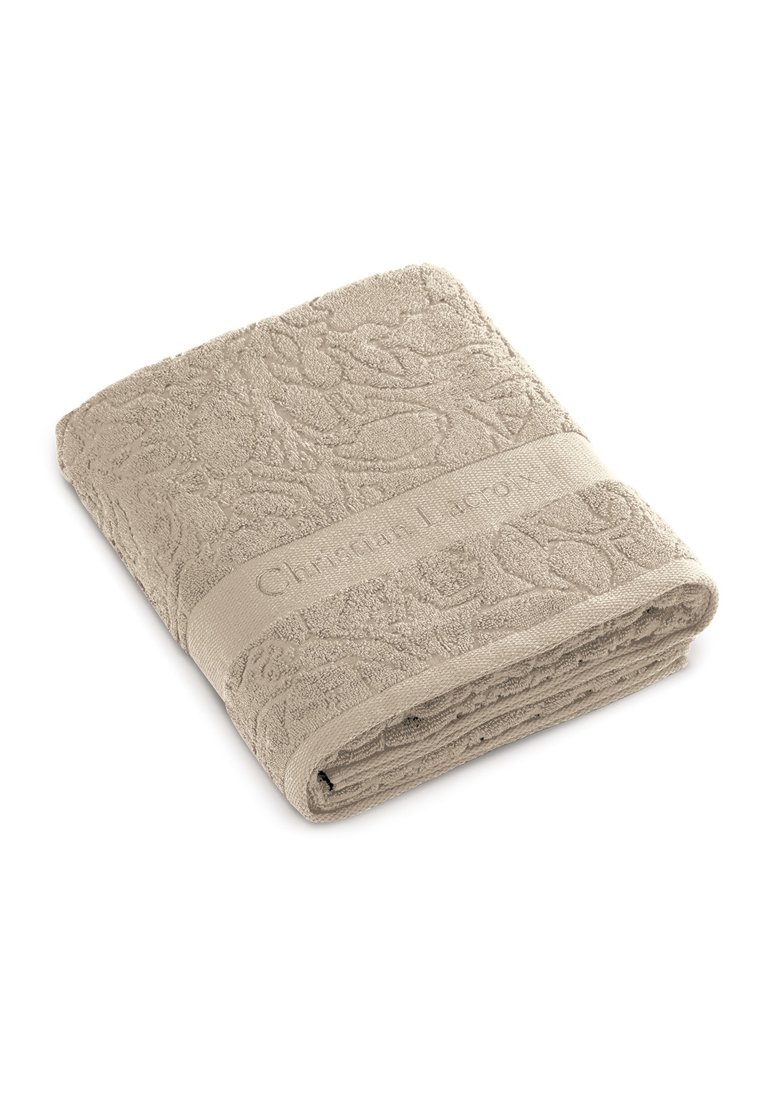 Serviette beige avec un motif floral texturé ; présente une bande en tissu avec un marquage en relief. Matériau doux et absorbant, plié soigneusement.