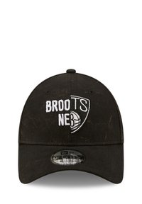 Crna bejzbol kapa s zakrivljenim vizirjem, s bijelim izvezenim natpisom "BROOTS NE3" i logom. Podesiva traka straga, teksturirana tkanina.
