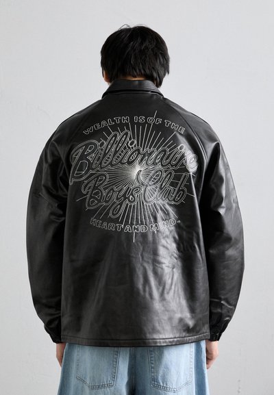 Schwarze Lederjacke mit einem aufgedruckten Design auf dem Rücken, das "Reichtum ist das Herz und der Verstand des Billionaire Boys Club" sagt.