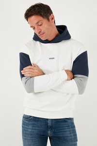 Hætte sweatshirt i hvid med marineblå og grå ærmer. Har et logo på brystet. Blødt materiale med en afslappet pasform.