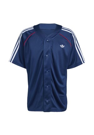 Πουκάμισο αθλητικό ναυτικό μπλε με κουμπιά, λευκές λεπτομέρειες με τρεις ρίγες στα μανίκια, κόκκινη επένδυση κοντά στους ώμους και μικρό λευκό λογότυπο στο στήθος.