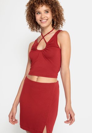 Rode crop top met een gerimpelde ronde halslijn en crisscross bandjes, gecombineerd met een rode minirok met een zijsplit. Gladde katoenmix stof.