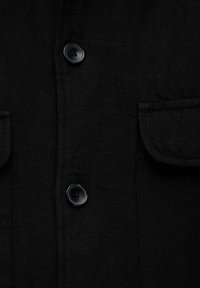 Juodas lino marškinis su apvaliais juodais mygtukais, dviem priekinėmis kišenėmis ir tekstūruota medžiaga. Paprastas dizainas su klasikinio stiliaus marškinių apykakle.