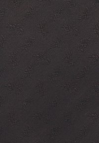 Czarna tkanina o teksturze z delikatnym wzorem kwiatowym. Wzór ma tkane struktury z lekko �żebrowanym wyglądem.