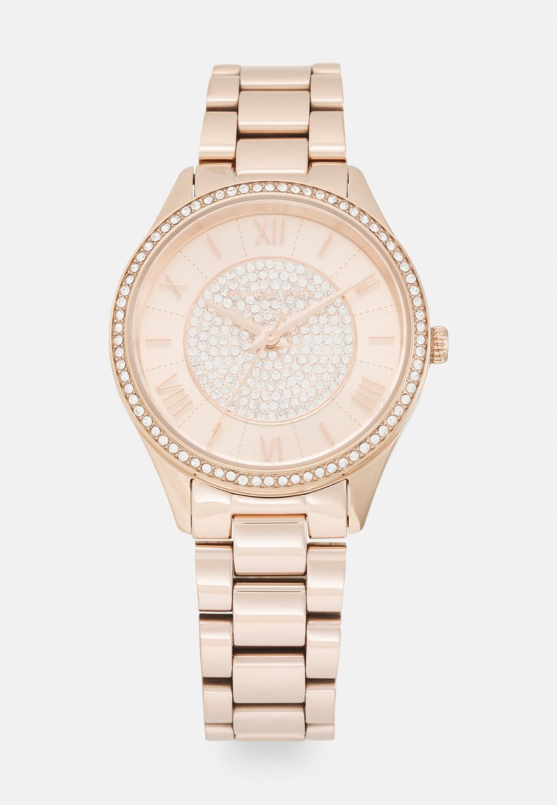 Złoty zegarek w odcieniu różowego złota z okrągłą tarczą, kryształowymi zdobieniami na obręczy i tarczy, rzymskimi cyframi oraz metalową bransoletą.