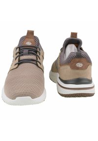 Beige Sport Schuhe haben ein strukturiertes Mesh-Obermaterial mit Wildlederakzenten, eine Schnürung, einen gepolsterten Schaft und eine Gummi-Sohle in Weiß und Braun.