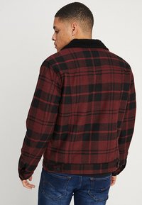 Wrangler TRUCKER - Chaqueta de entretiempo - madder brown