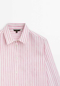 Chemise blanche à boutons avec des rayures verticales roses et un col pointu, montrée de la poitrine vers le haut sur fond blanc.