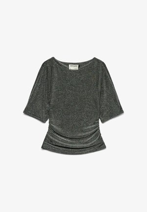 Lühikeste varrukatega särk, mis on valmistatud tumedast hallist metallist kangast. Omab laia lõiget, mida iseloomustab kokkusurutud tekstuur vöökohtades ja lai kaelus.