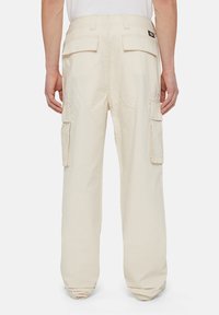 Beige cargobroek met een relaxte pasvorm, voorzien van dubbele zijzakken, achterzakken en een ronde patchdetail aan de achterkant. Gemaakt van katoen.