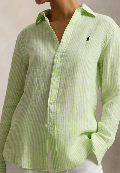 Ανοιχτό πράσινο, ριγέ πουκάμισο μακρυμάνικο από ελαφρύ ύφασμα. Διαθέτει κουμπιά στο μπροστινό μέρος και ένα μικρό κέντημα με λογότυπο στο στήθος.