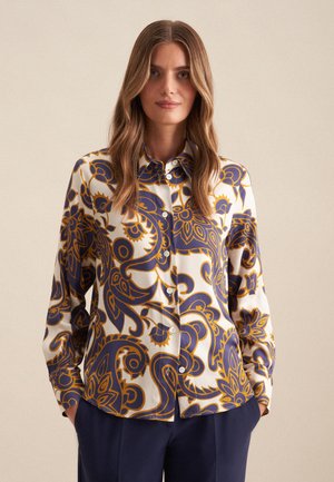 Witte blouse met lange mouwen, versierd met marineblauwe en gouden weelderige paisleypatronen, met een knoopsluiting aan de voorkant en een losse pasvorm.