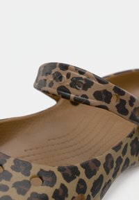 Παπούτσι με σχέδιο λεοπάρδαλης κατασκευασμένο από εύκαμπτο υλικό, με στρογγυλεμένο σχεδιασμό, υποστηρικτικό λουράκι και υφή στην εσωτερική σόλα με οπές αποστράγγισης.