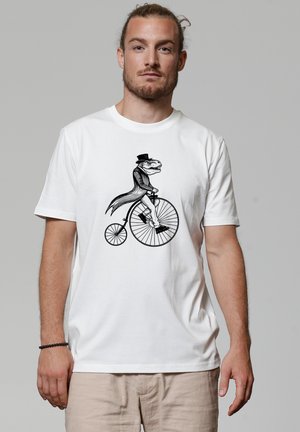 Witte t-shirt met korte mouwen featuring een zwarte illustratie van een dinosaurus in een hoge hoed die op een vintage fiets met een grote voorwiel rijdt.