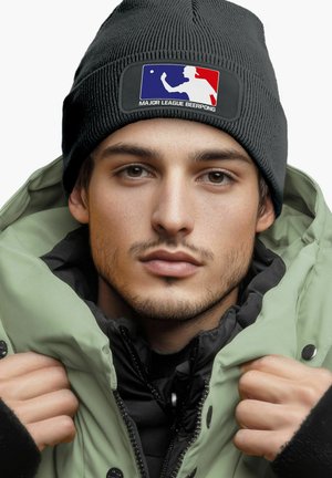 Black knit beanie with a logo patch; green puffer jacket with a zipper and button closures; black inner layer. Smooth texture, layered look.