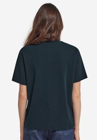 Mörk marinblå kortärmad t-shirt med rund halsringning och avslappnad passform. Slät bomullstyg; inga synliga mönster eller detaljer.