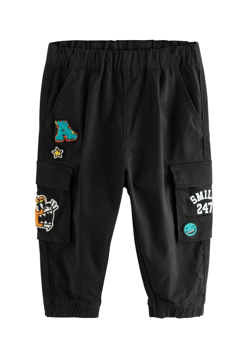 Pantalons cargo noirs avec taille élastique, présentant des détails en patchs comprenant des lettres et des caractères, avec des poches latérales pour le rangement.