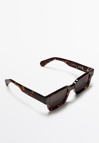 Schildpatt-Sonnenbrille mit rechteckigen Gläsern, texturiertem Rahmen, dunklen Gläsern und metallischen Akzenten an den Bügeln. CE-gekennzeichnet.