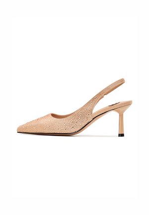 Sandalino con tacco alto in rete nude decorato con borchie metalliche. Punta affusolata e tacco a stiletto sottile, dotato di una fascia posteriore testurizzata.