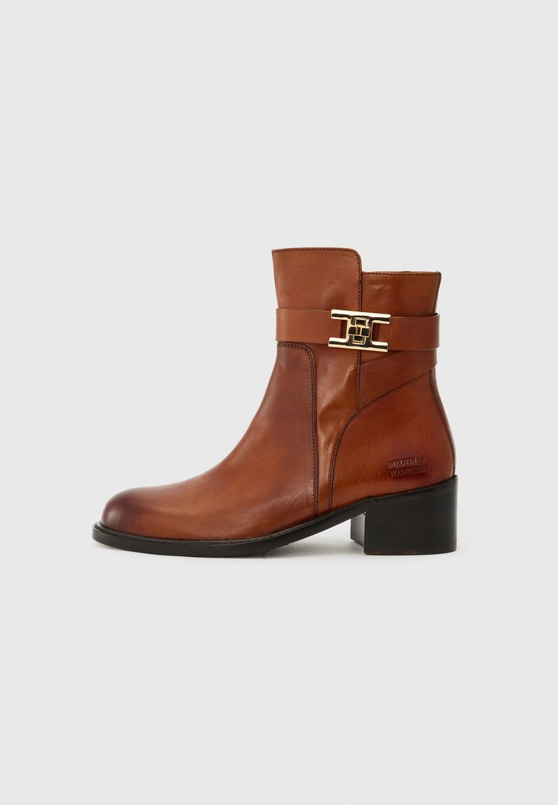 Bottines en cuir marron avec un bout rond, un talon bloc de hauteur intermédiaire et des accents en métal doré sur la sangle. Logo embossé sur le côté.