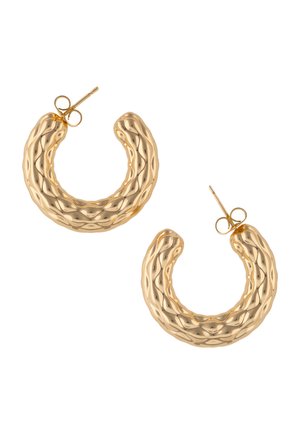 Pari kultaisia korvarenkaita, joissa on teksturoitu aaltoileva ja fasetoitu pinta sekä taustakiinnitys, valkoisella taustalla.