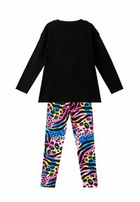 Zwarte longsleeve top gecombineerd met multicolore leggings met een levendig dierenprintontwerp in roze, blauw, geel en groen.