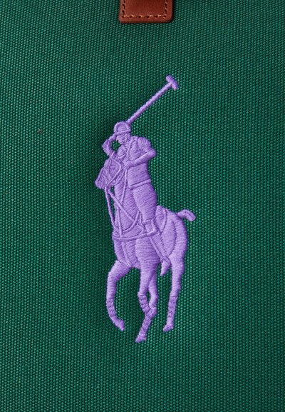 O pânză verde cu o broderie în relief de lavandă reprezentând un jucător de polo pe cal, având texturi detaliate și un accent din piele maro.