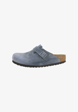 Blauwe suède klomp met verstelbare gesp en metalen sluiting. Voorzien van een kurken binnenzool en een getextureerde zwarte rubberen buitenzool voor grip.