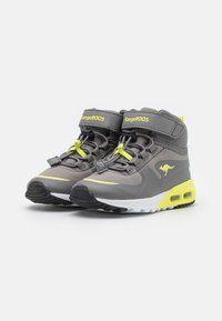 Gray high-top sneakers with neon yellow accents and detailing, featuring a secured strap, lace closure, and a cushioned sole.