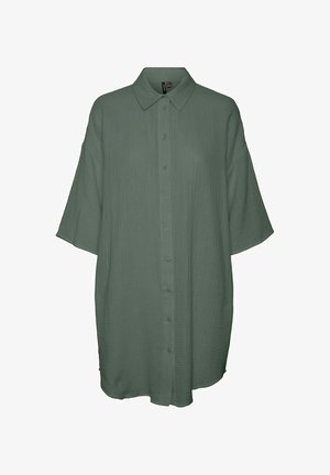 Chemise verte, surdimensionnée, en tissu texturé, avec un col classique, des manches courtes et une patte de boutonnage à l'avant.