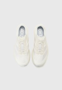 White athletic shoes with a textured upper, featuring a smooth heel, flat laces, and brand logo in light grey, designed for performance.