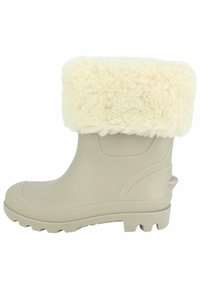 Beige rubber laars met een crèmekleurige faux fur boord, ribbelzool voor grip, en een texturepatroon op de bovenkant. Versterkte hakdetails.