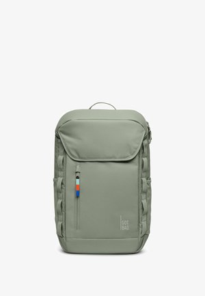 Sac à dos en tissu vert avec un rabat supérieur, une poche avant, des détails de fermeture éclair bleue, orange et blanche, ainsi que des accents de sangle sur les côtés. Dispose d'une poignée supérieure.