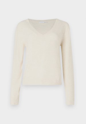 Cremefarvet V-hals langærmet sweater med ribbede manchetter og kant, præsenteret mod en ensfarvet hvid baggrund.