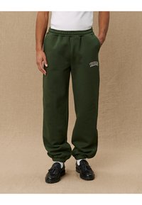 Green sweatpants made from soft fabric with a relaxed fit, featuring an elastic waistband and "Yale" embroidered in white.