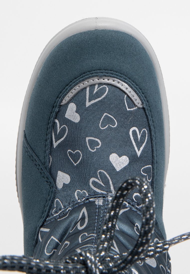 Baskets en daim bleu avec un tissu à motifs présentant des cœurs blancs. Des accents gris et des lacets texturés noirs complètent le design.