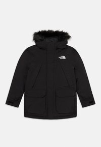 Parka noire isolante avec capuche en fausse fourrure, grandes poches avant et logo sur la poitrine. Elle dispose d'une fermeture éclair et de poignets réglables.