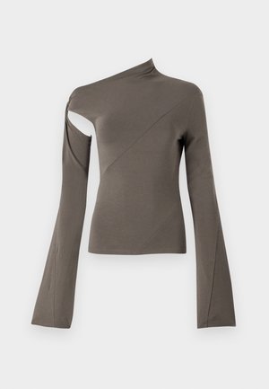 Haut à manches longues asymétrique en vert olive, présentant une découpe sur une épaule, une texture lisse et un design de manches évasées.