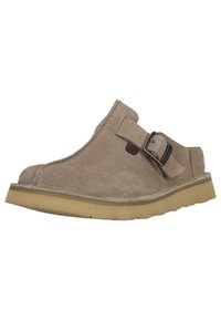 Beige suede slip-on shoe with a rounded toe, a buckle strap, and a textured rubber outsole. No visible patterns or logos.