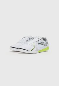 Buty sportowe z białą syntetyczną cholewką, czarnymi akcentami i limonkowymi detalami. Posiadają teksturowany wzór oraz gumową podeszwę zapewniającą przyczepność.