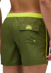 Shorts de bain verts avec une ceinture élastique jaune vif, des rayures sur les côtés et une poche arrière ornée d'un détail de design en jaune.
