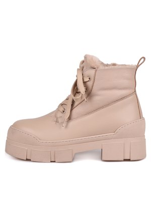 Beige leren enkellaarsjes met een zachte binnenvoering, ronde neus en een dikke, gestructureerde rubberen zool. Veters en een handvat aan de achterkant.
