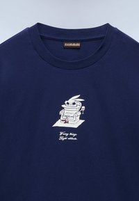 Navy shirt with a small graphic of a relaxed rabbit wearing sunglasses and red heels, holding a wine glass, and text reading "Wrong things Right attitude."